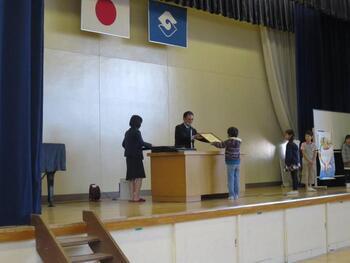 写真：壇上で表彰状を受け取る松田さん
