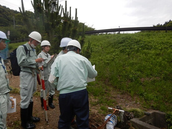 地元住民に地すべり防止施設（排水路）の説明をしている写真