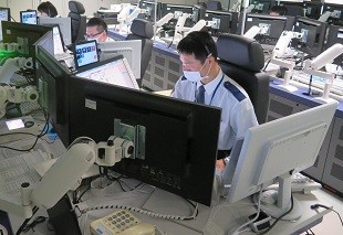 写真:110番センター静岡の室内で作業する人々