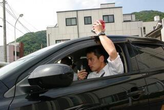 写真:車に乗り犯罪捜査中の刑事