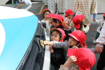 写真：パトカーの旭日章に興味津々な園児たち