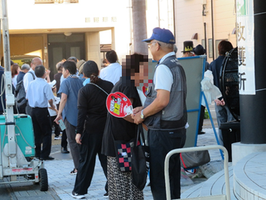 写真：「特殊サギ被害防止うちわ」の配布