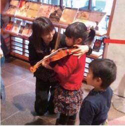 写真：京極美穂子氏とバイオリンに触れる子供