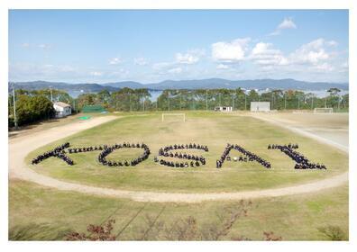 写真：KOSAIの形に並んで座っている様子