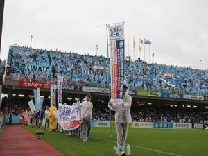 写真：のぼり旗と横断幕を持ったサッカー場での啓発活動の様子