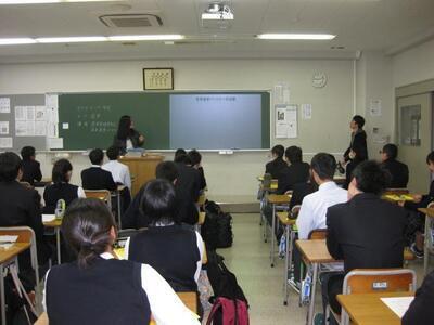 写真：黒板に映し出されたスクリーンを見ている生徒たちの様子
