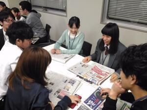 写真：新聞を見ながらグループワークをする学生たち