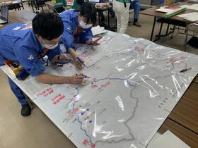 写真：大きな地図に書き込みをしている衣料救護訓練の様子