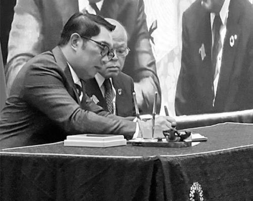 写真:知事が覚書に署名する様子