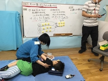 写真:算数の授業中、痰が出しやすい姿勢をとりながら排痰を促すケアをしています