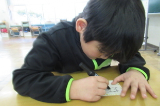 写真：メッセージを書く児童