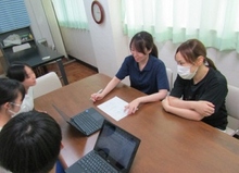 写真：調理主任とともに生徒と打合せをする筆者