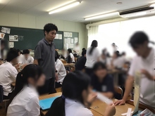 写真：レポートの報告をする生徒と筆者（左）