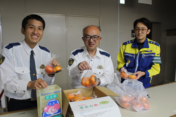 写真:署長の柿を手にする細江警察署員ら