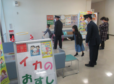 写真：警察官と輪投げに参加する子どもたち